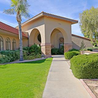 A beautiful architectural structure with lush green landscaping and a pathway leading to the entrance.