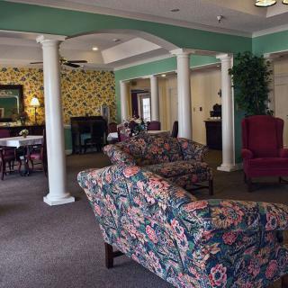A traditional living room with floral patterned sofas and white columns.