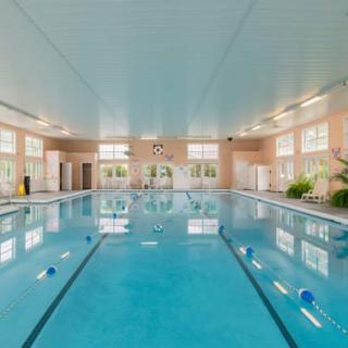 A spacious indoor swimming pool with clear water and natural lighting.