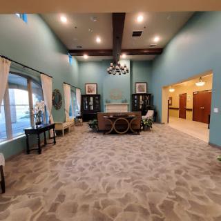 A spacious and elegantly designed lobby featuring blue walls, decorative furniture, and abundant natural light.
