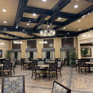 Elegant dining area with stylish chandeliers and neatly arranged tables and chairs.