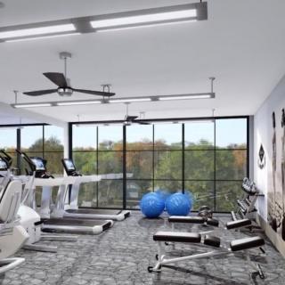 A modern gym with various exercise equipment and large windows overlooking a scenic view.