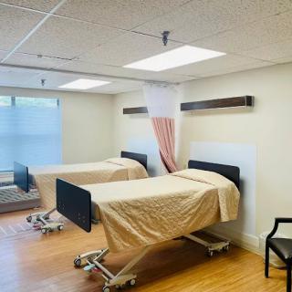 An empty hospital room with two beds and medical equipment.