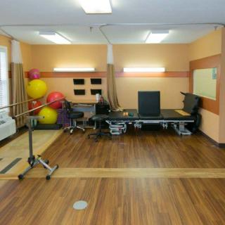 A physical therapy room equipped with exercise balls, treatment tables, and other rehabilitation equipment.