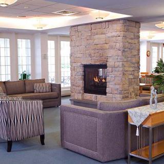 A cozy living room featuring a central stone fireplace and comfortable seating.