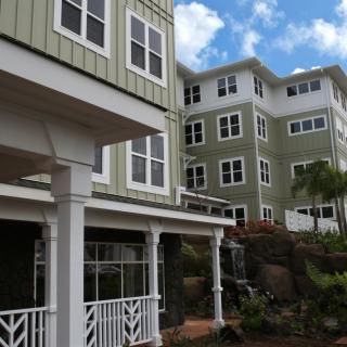 Modern residential buildings with multiple windows against a blue sky.
