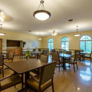 A spacious dining area featuring tables and chairs, well-lit with natural light from large windows.