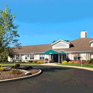 A residential building with a landscaped driveway and blue sky.