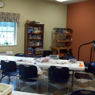 A classroom setup with tables and chairs, equipped for crafting activities.