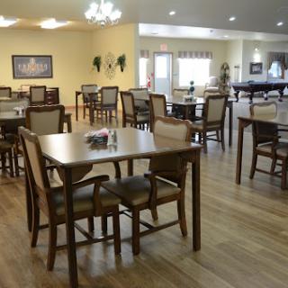A spacious dining area featuring wooden tables and chairs, designed for comfort and social gatherings.