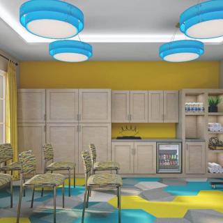 A modern kitchen and seating area with blue ceiling lights and yellow walls.
