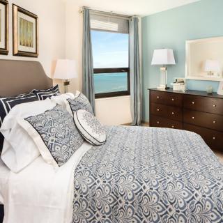 A cozy bedroom with coastal views and elegant decor.