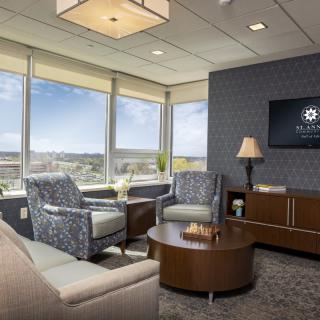 A modern office lounge with comfortable seating and a city view.