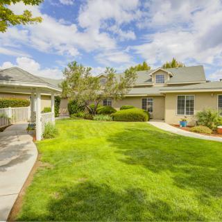 A suburban house with a well-maintained lawn and a gazebo in the garden.