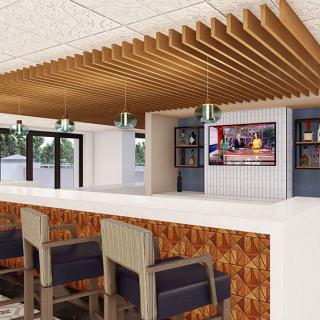 A modern bar interior with a sleek counter, wooden ceiling accents, and comfortable seating.