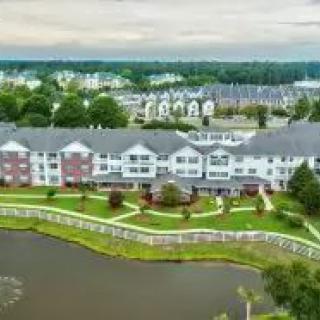 Aerial view of a residential complex near a lake in a suburban area.
