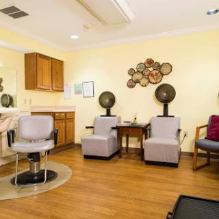 A cozy hair salon waiting area featuring stylish seating and professional hair styling stations.