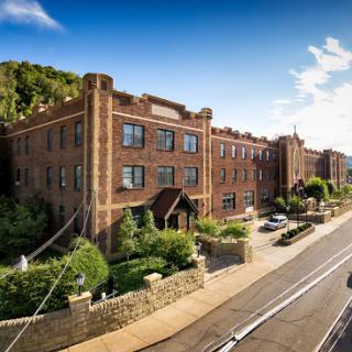A beautifully designed brick building set against a clear blue sky, blending urban architecture with natural surroundings.