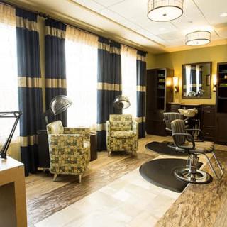 A modern salon interior featuring styling chairs, mirrors, and elegant decor.