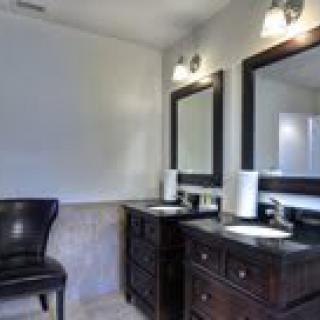 A modern bathroom with double sinks and large mirrors.