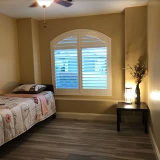 A cozy bedroom with a single bed and a nightstand beside a window.