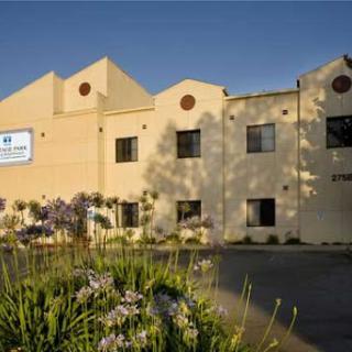 A well-designed building surrounded by blooming flowers in a sunny setting.