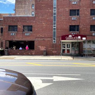 A view of a brick building featuring a restaurant with outdoor seating, captured on a sunny day.