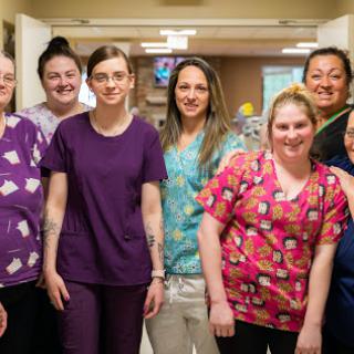 A dedicated team of healthcare professionals posing together in a hospital setting.