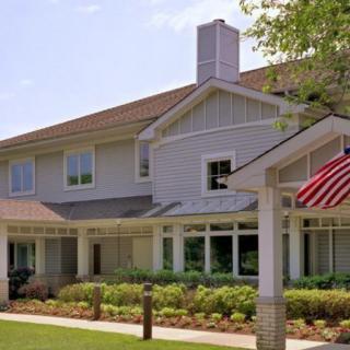 A suburban residential building with well-maintained landscaping and an American flag displayed.