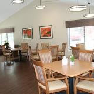 A well-lit dining area with wooden tables and chairs.