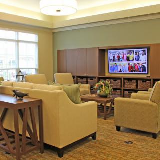 A modern lounge with comfortable seating and a large television.