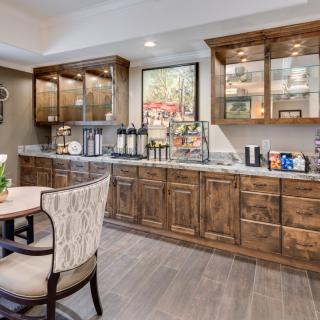 A modern kitchen with wooden cabinets and a cozy dining area.