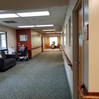 A view of a hospital hallway featuring a waiting area with seating.