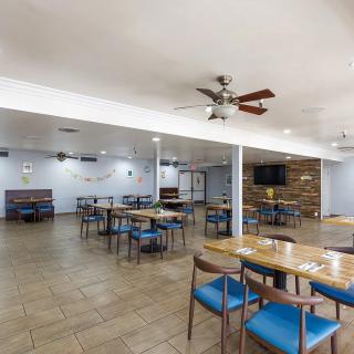 A modern restaurant interior with tables and chairs arranged in an open seating area.