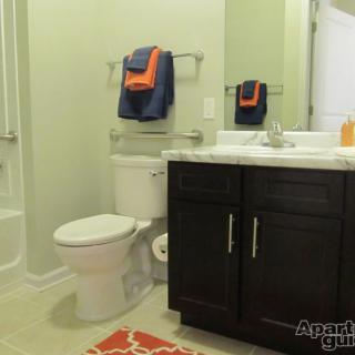 A well-organized bathroom with a sink, toilet, and decorative towels.