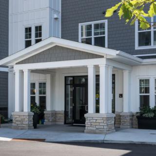 A modern building entrance with columns and large windows.