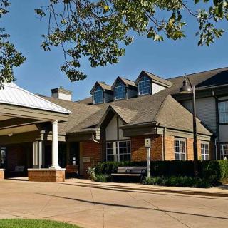 A suburban residential building with a well-maintained exterior and surrounding greenery.