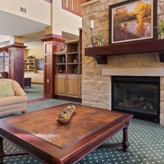 A cozy living room with a fireplace, artwork above the mantel, and comfortable seating.