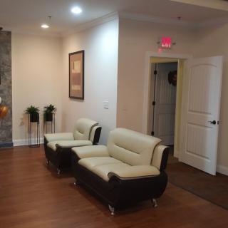 A cozy waiting room with modern furniture and wooden flooring.