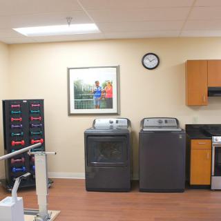 A room featuring a washer and dryer set with kitchen utilities and storage cabinets.
