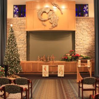 A serene interior of a church adorned with festive Christmas decorations, featuring a beautifully decorated tree and an altar.