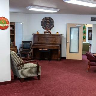 A cozy office lobby featuring a piano and comfortable seating.