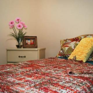 Cozy bedroom with a colorful bedspread and decorative accents.