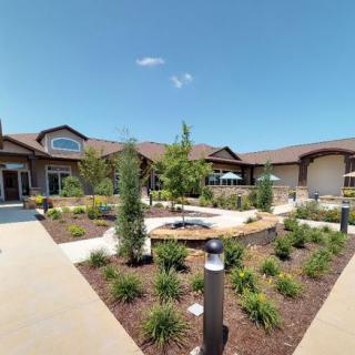 A well-maintained residential building with landscaped gardens on a sunny day.