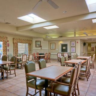An empty dining room with tables and chairs under skylights.