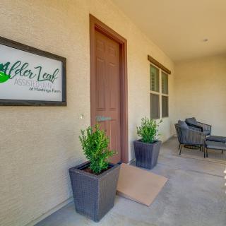 A welcoming porch with potted plants and a seating area next to the entrance door.