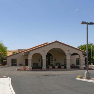 A single-story building with large arches over the entrance, situated in a sunny outdoor setting.