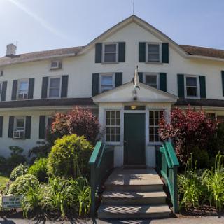 A charming house with a welcoming entrance surrounded by lush greenery.