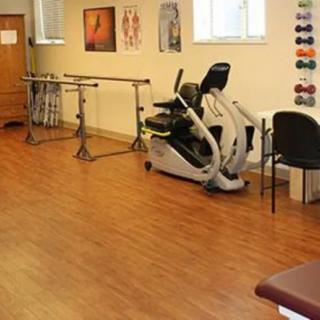A physical therapy room equipped with exercise equipment and rehabilitation tools.