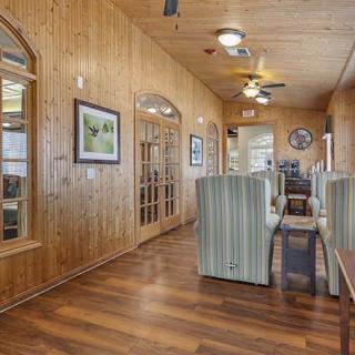 A cozy hallway with wood paneling, featuring comfortable seating and framed artwork.
